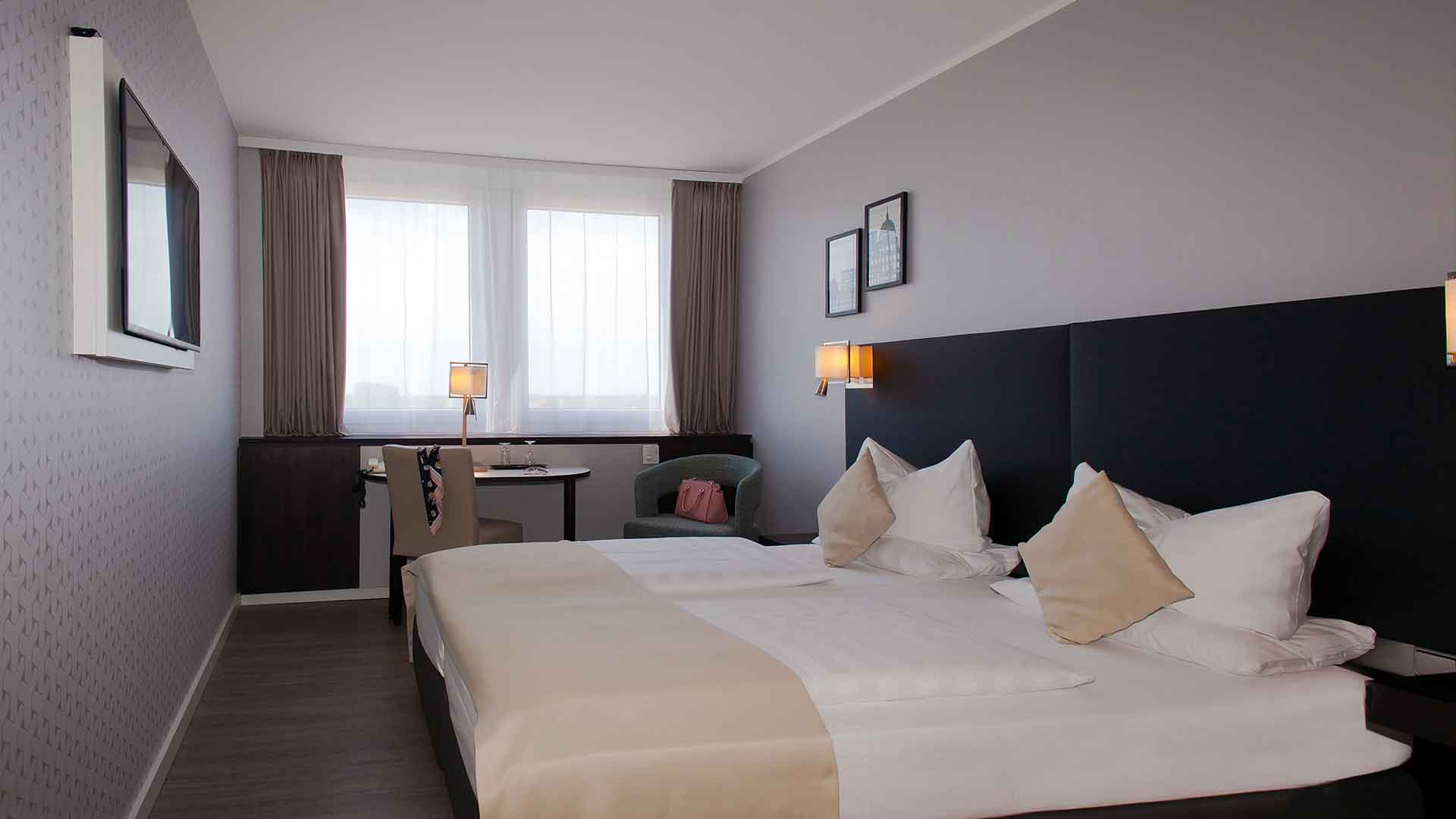 Modernes Hotelzimmer im Mercure Hotel Potsdam mit großem Bett und gemütlicher Ausstattung
